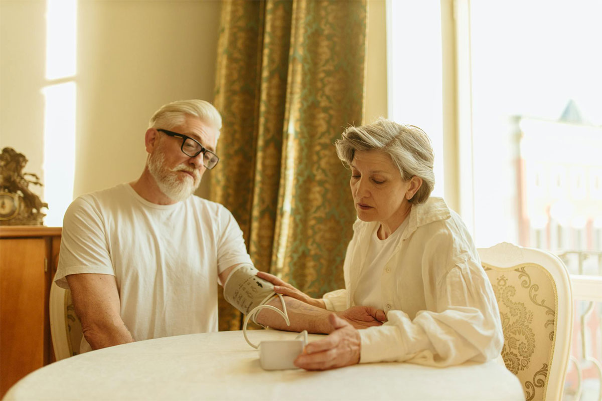 Elderly couple checking blood pressure